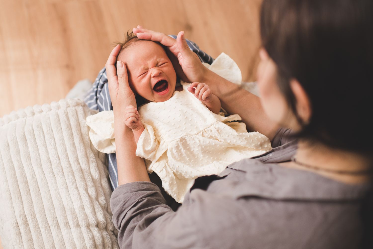 Ein schreiendes Baby im Schoß seiner Mutter