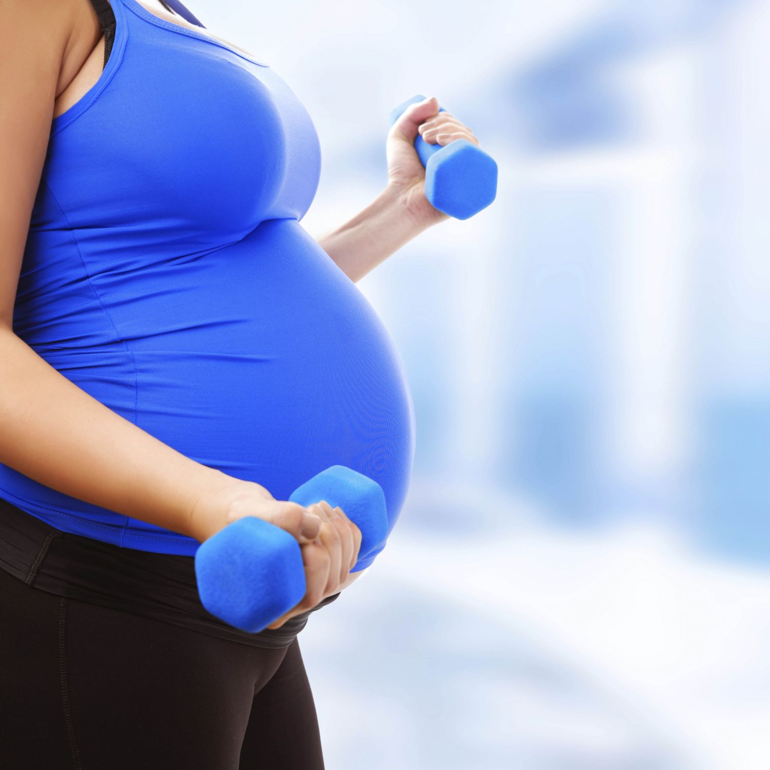 Schwangere mit Hanteln in der Hand. Thema: Schwangerschaftskurse 